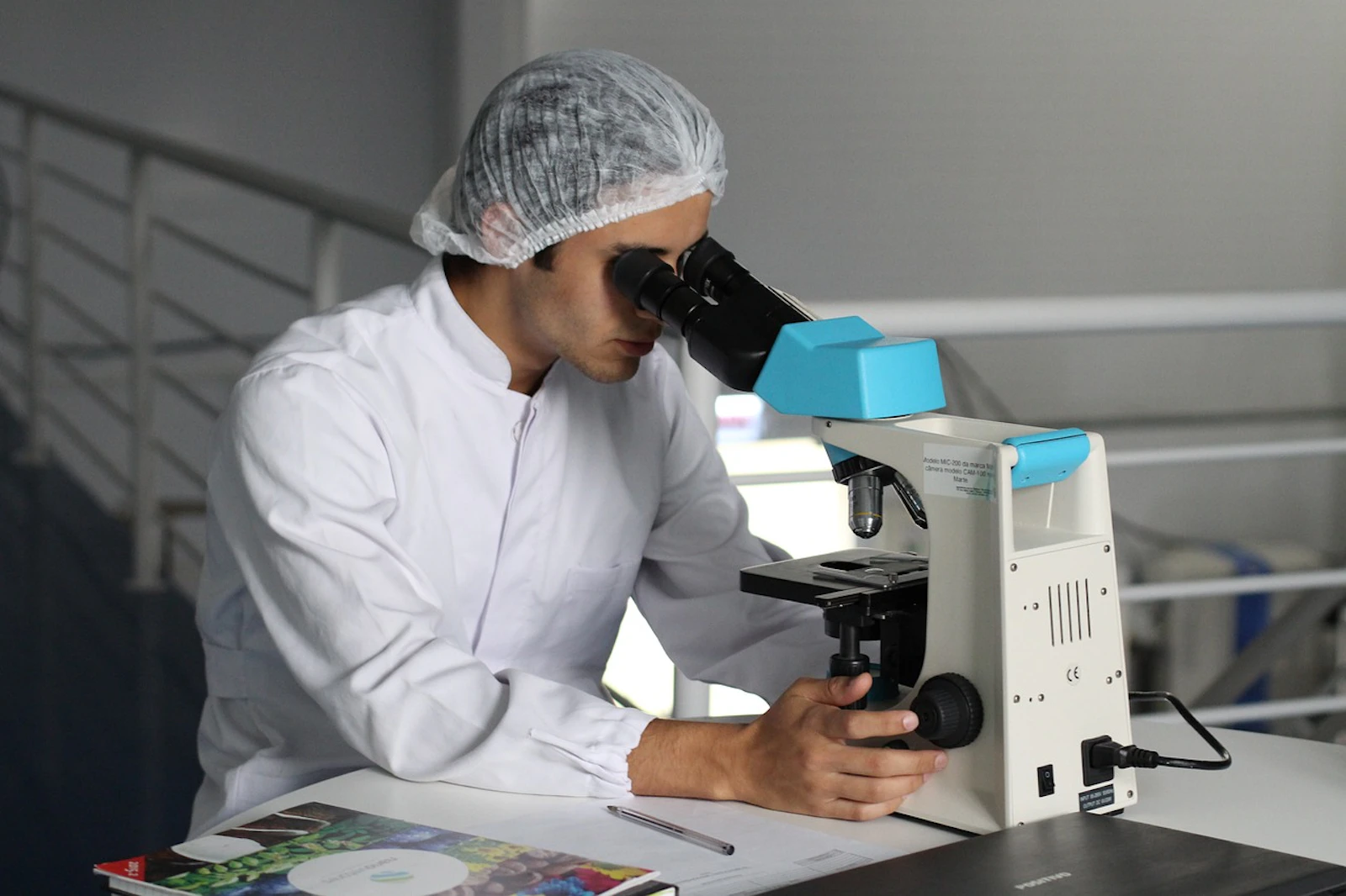 a pharmaceutical scientist looking into a microscope