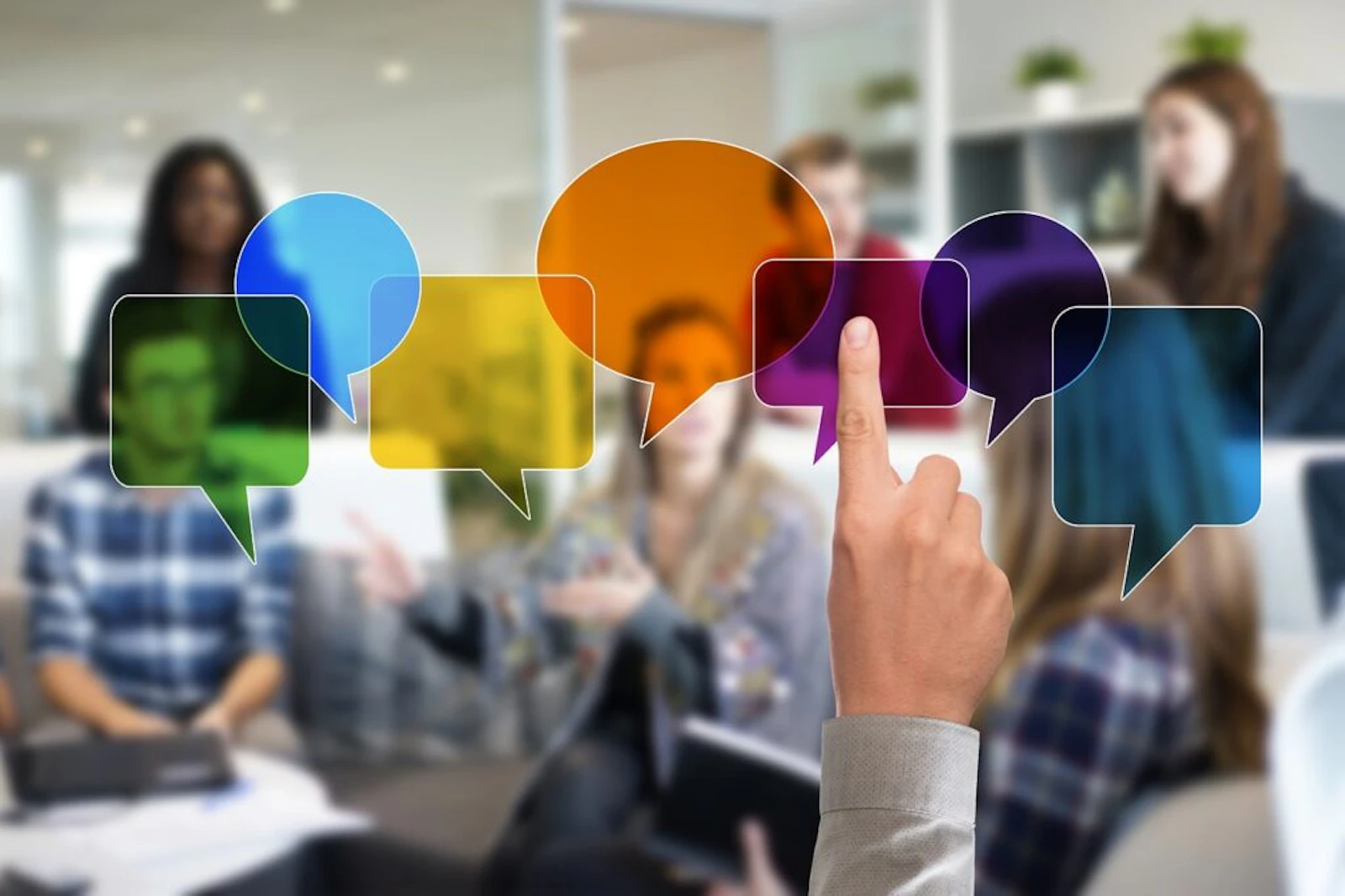 Hand selecting colorful speech bubbles representing multichannel communication