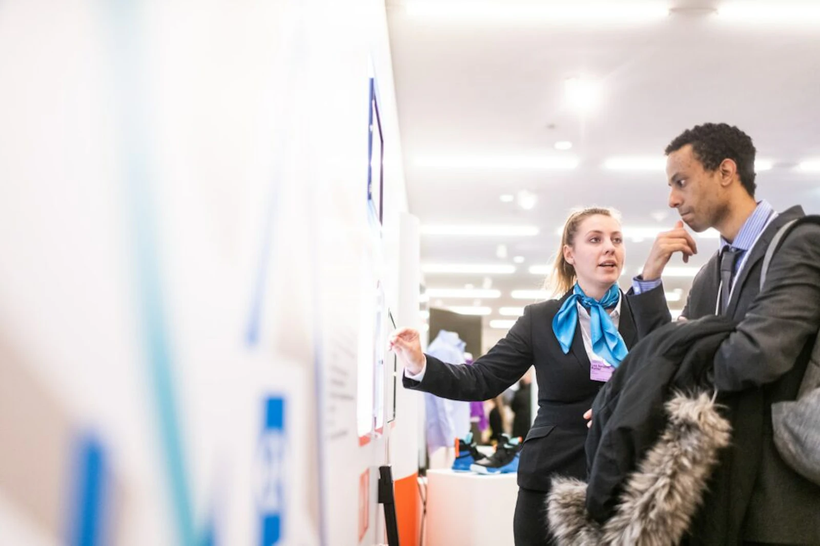 Two professionals discussing products at a trade show or exhibition stand