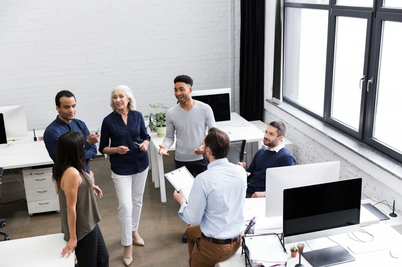 diverse team having a casual standing meeting in a modern office