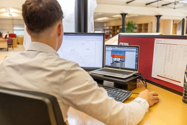 Man working at a desktop computer in a corporate office environment