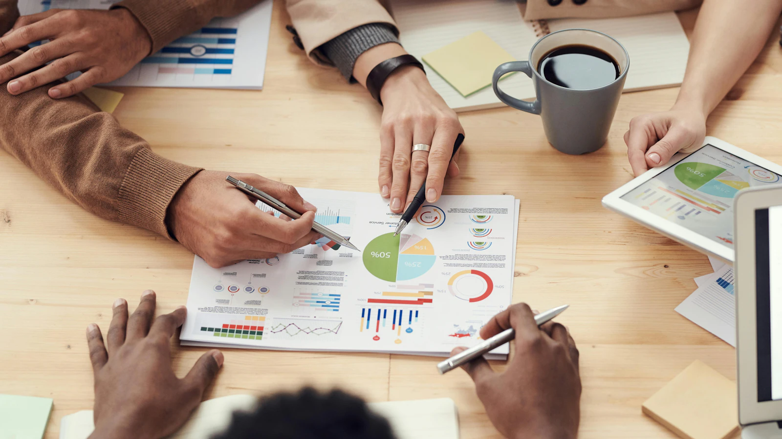 Team reviewing business charts and data reports together at a meeting table