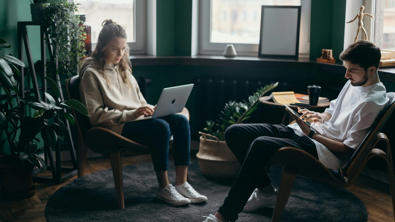 Two people in an office working on a laptop and tablet