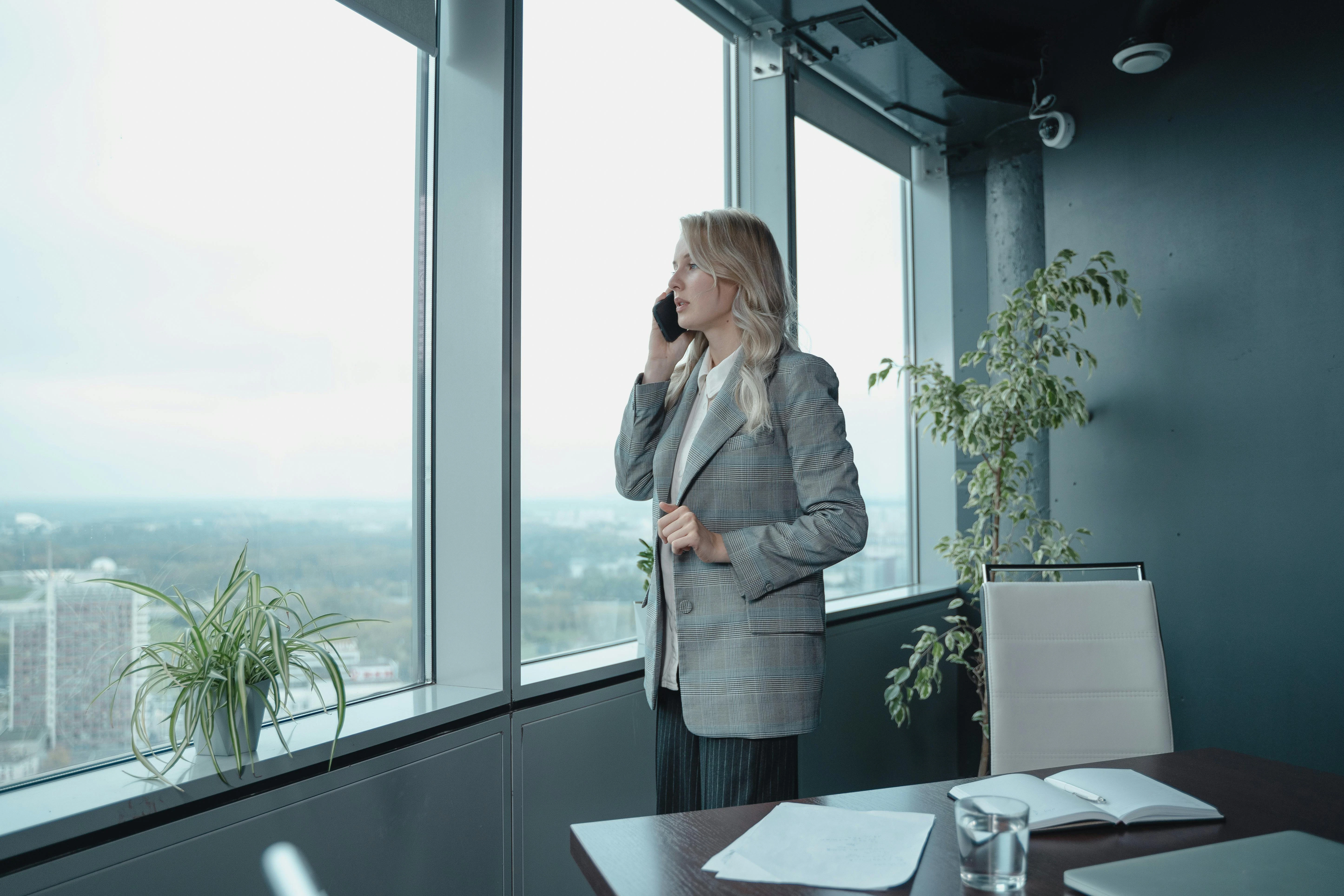 Employee Standing Near Windows Talking on the Phone