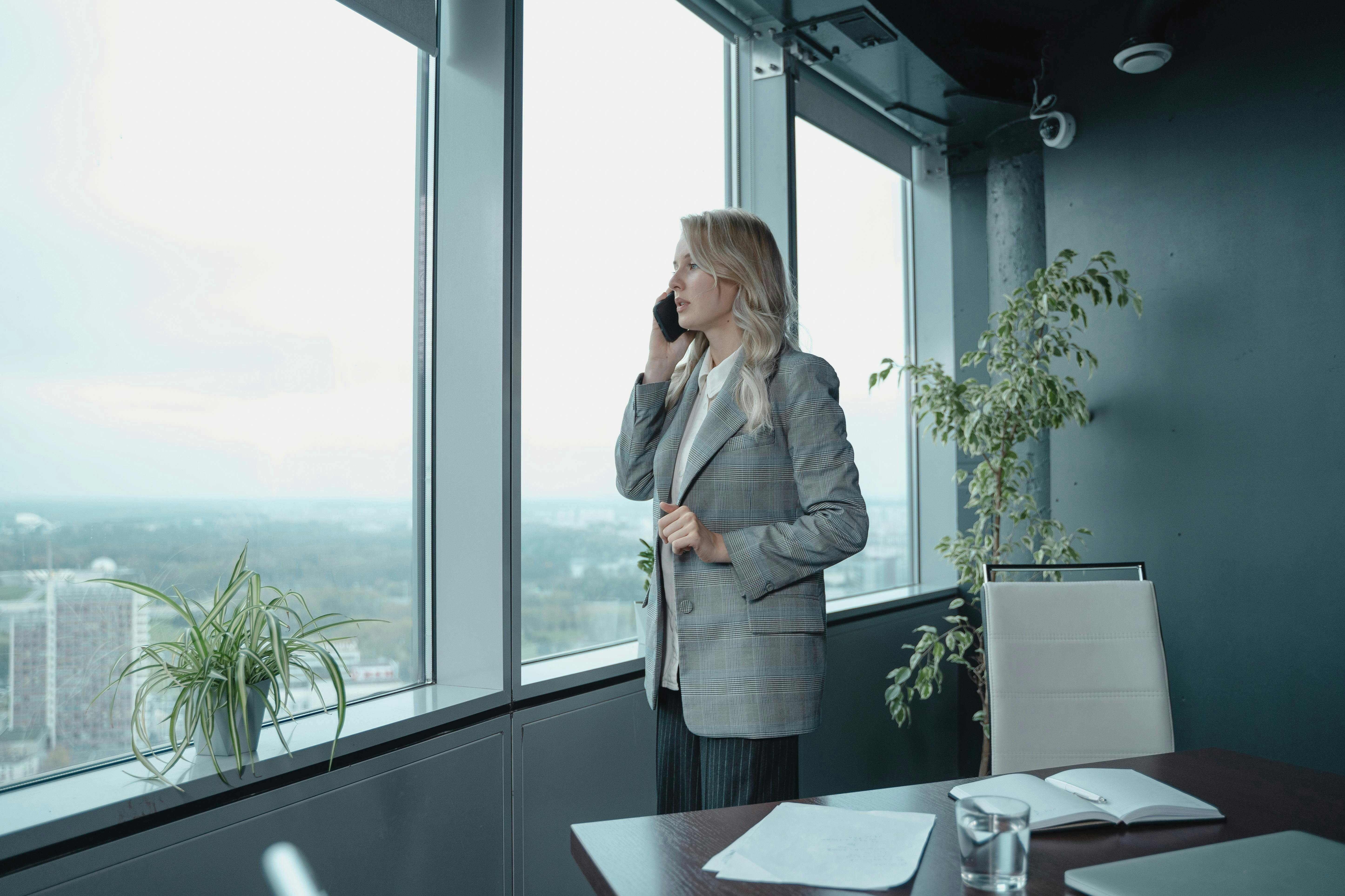 Employee Standing Near Windows Talking on the Phone