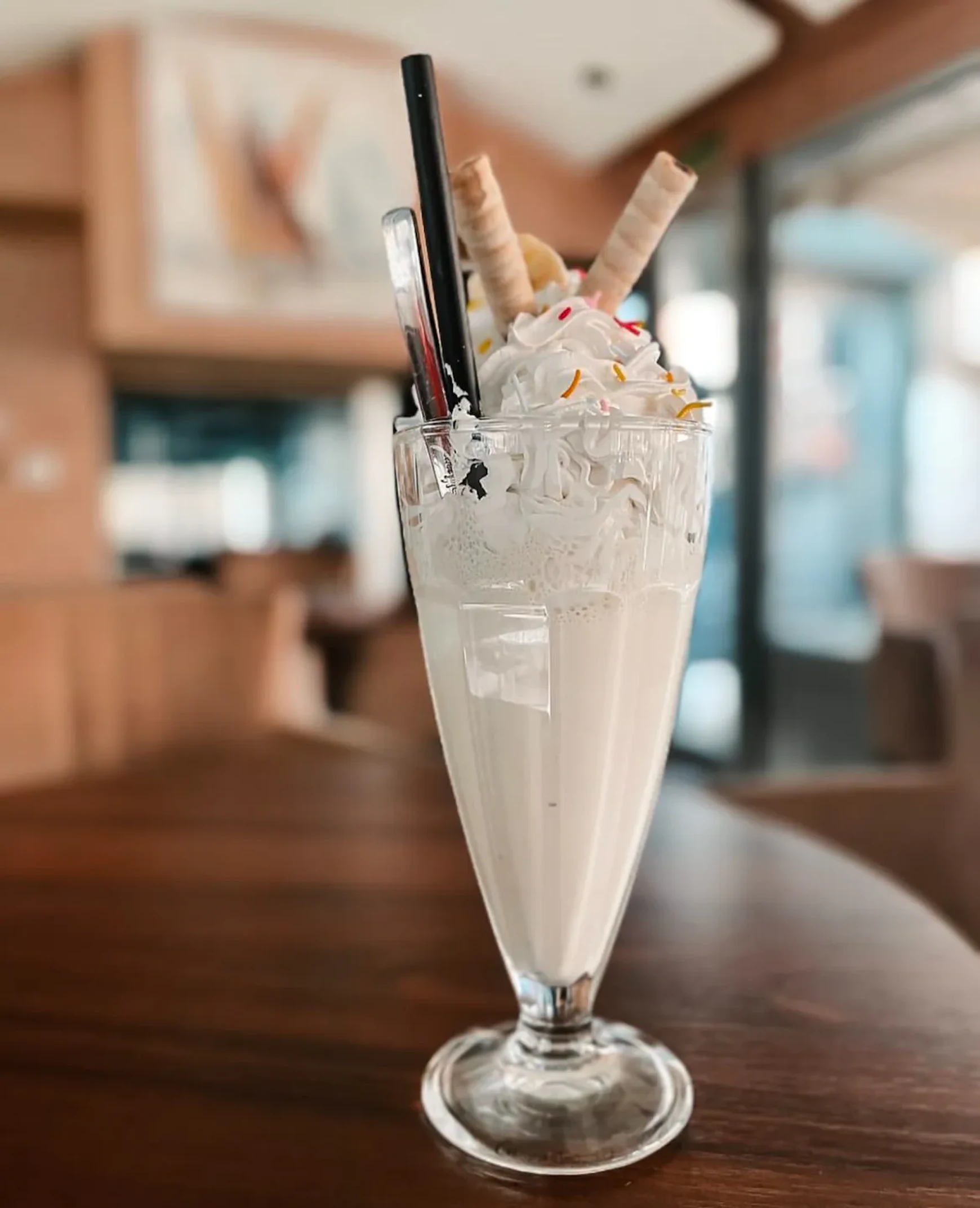 Frape banana sa šlagom i štapićima od vafla, u lokalu