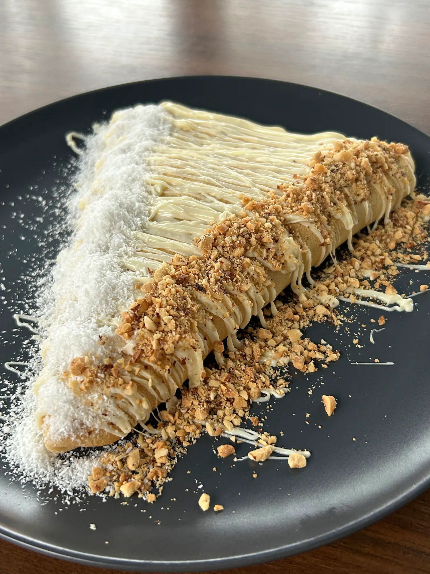 Palačinka sa Raffaello kremom, lešnikom i kokosom na tamnom tanjiru