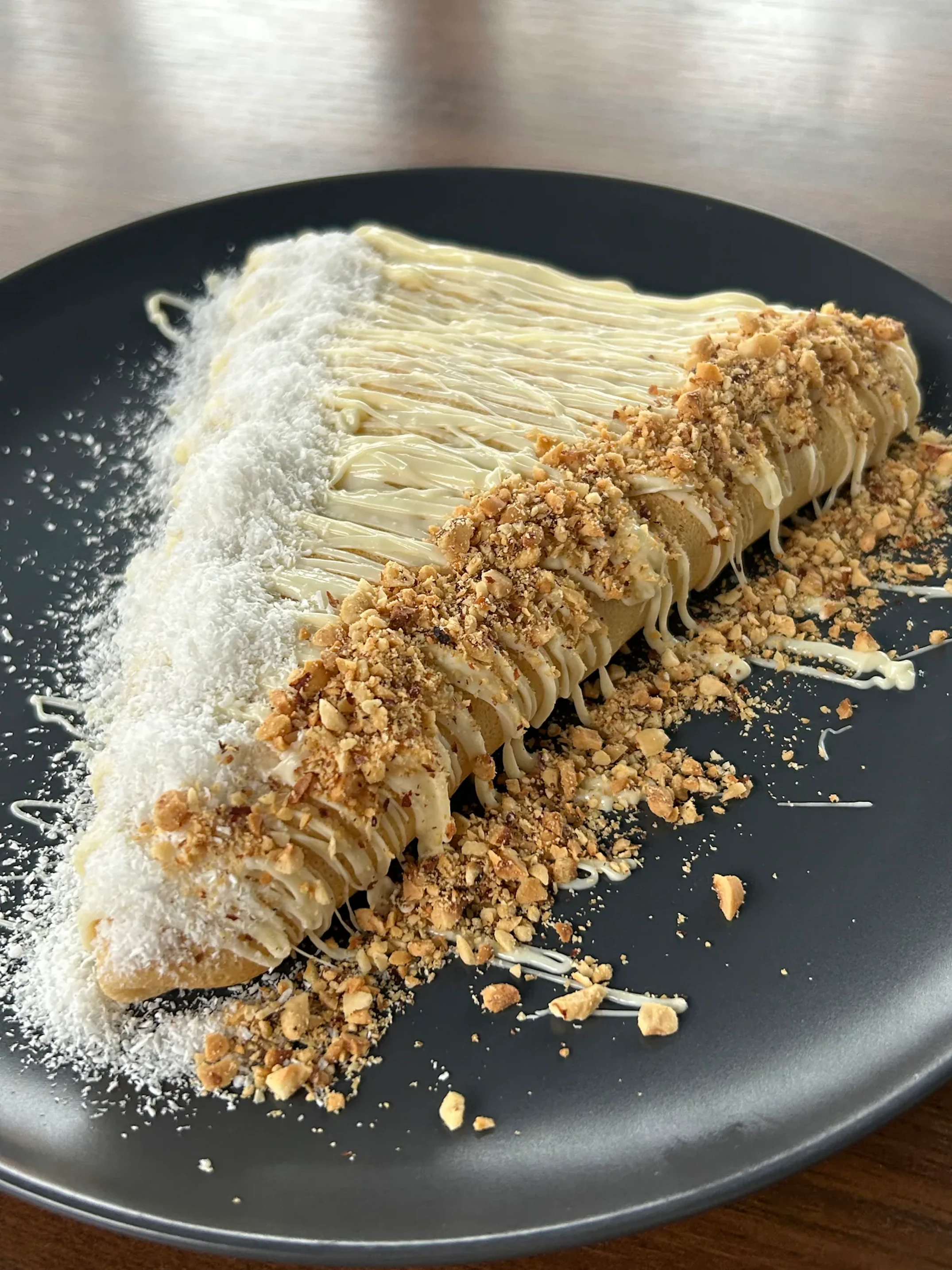 Palačinka sa Raffaello kremom, lešnikom i kokosom na tamnom tanjiru