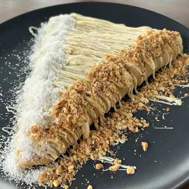 Palačinka sa Raffaello kremom, lešnikom i kokosom na tamnom tanjiru