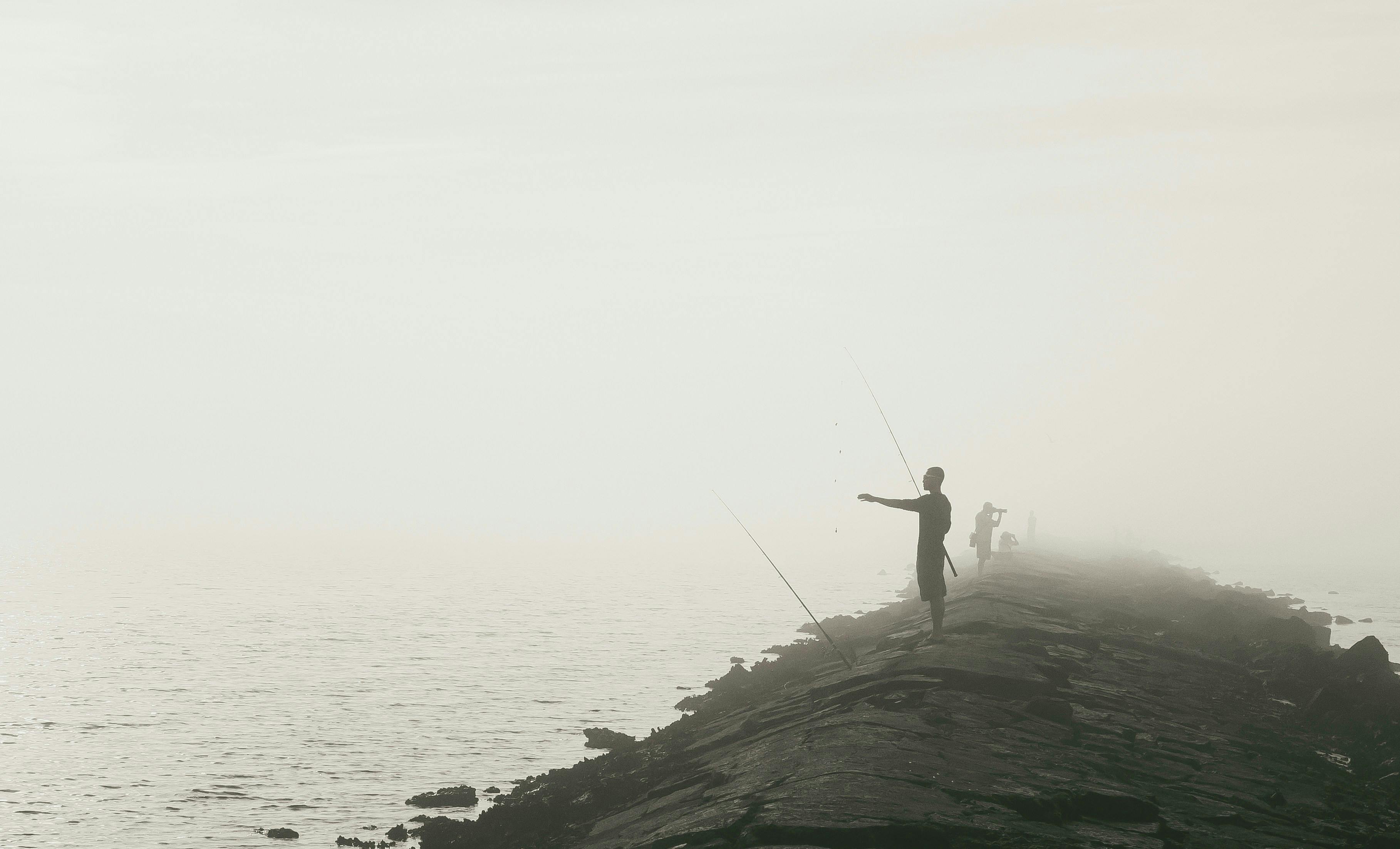 Man fishing at foggy beach