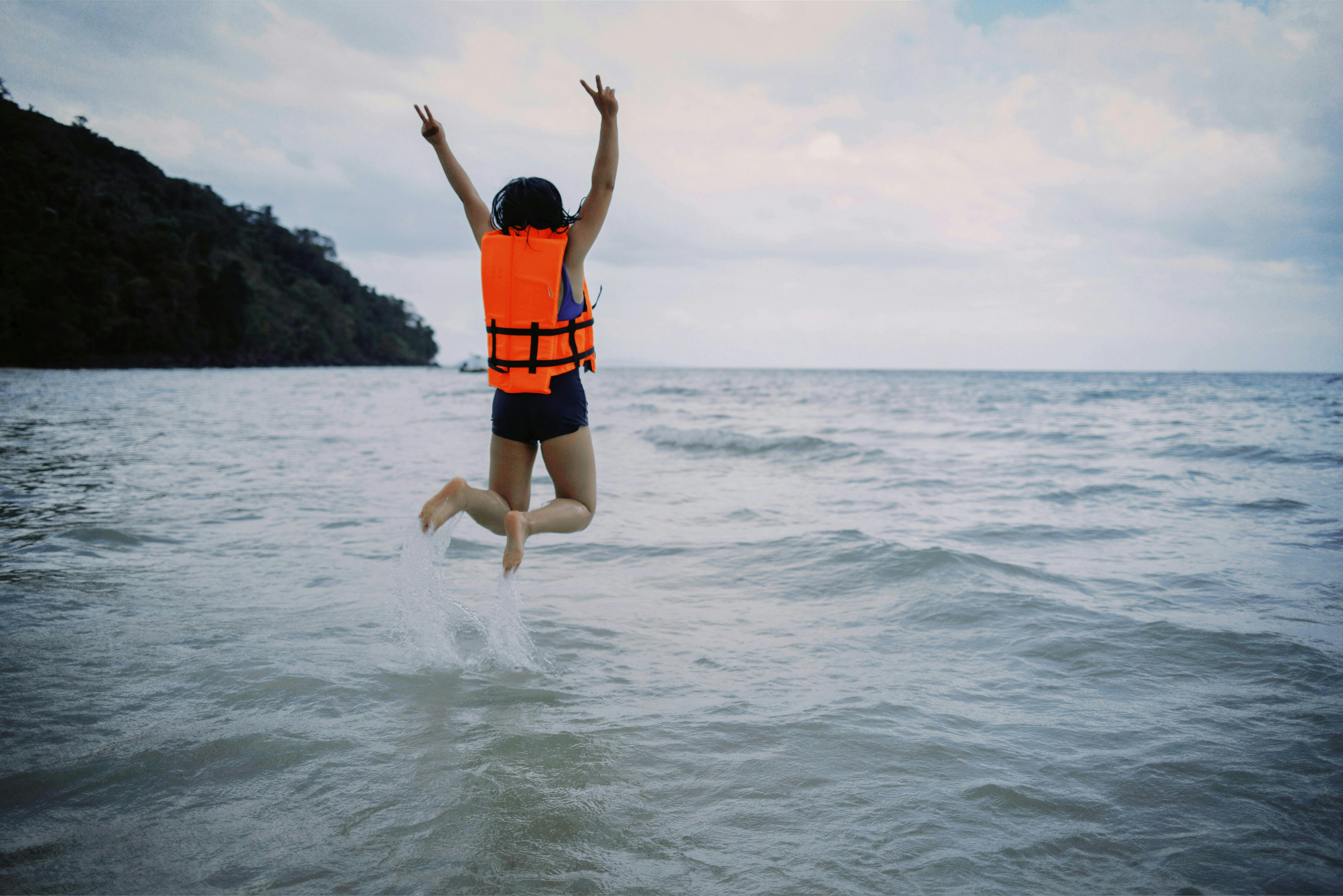 Child with life vest jumping into water