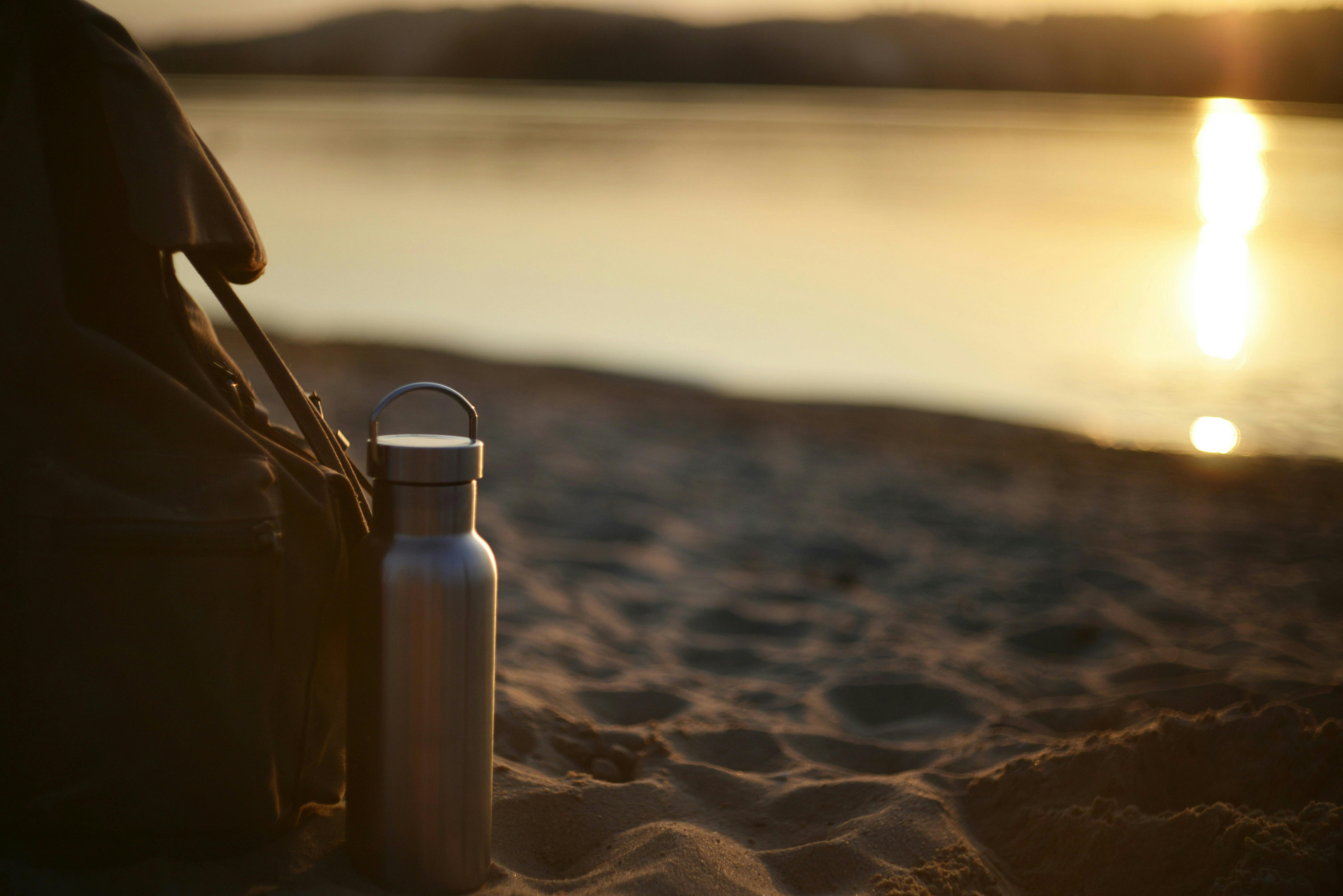 Backpack with a silver water bottle at the beach