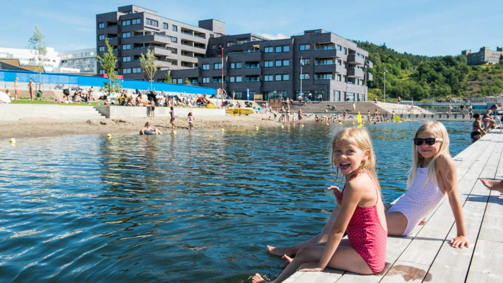 Two girls sitting on the pier of Sorenga Seawater Pool - Oslo, Norway.