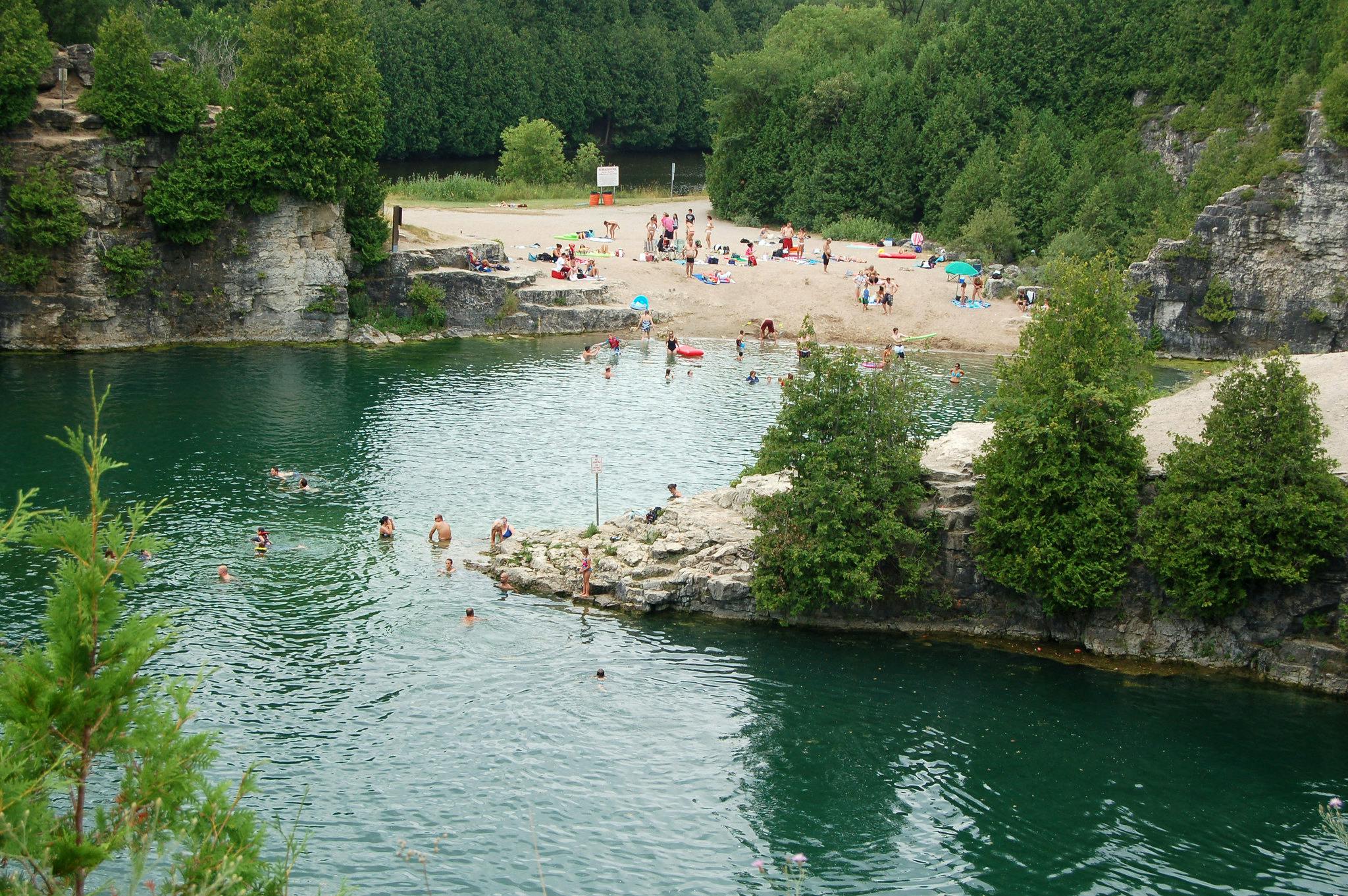 Photo of people swimming in the blue-green waters of the Elora Quarry.