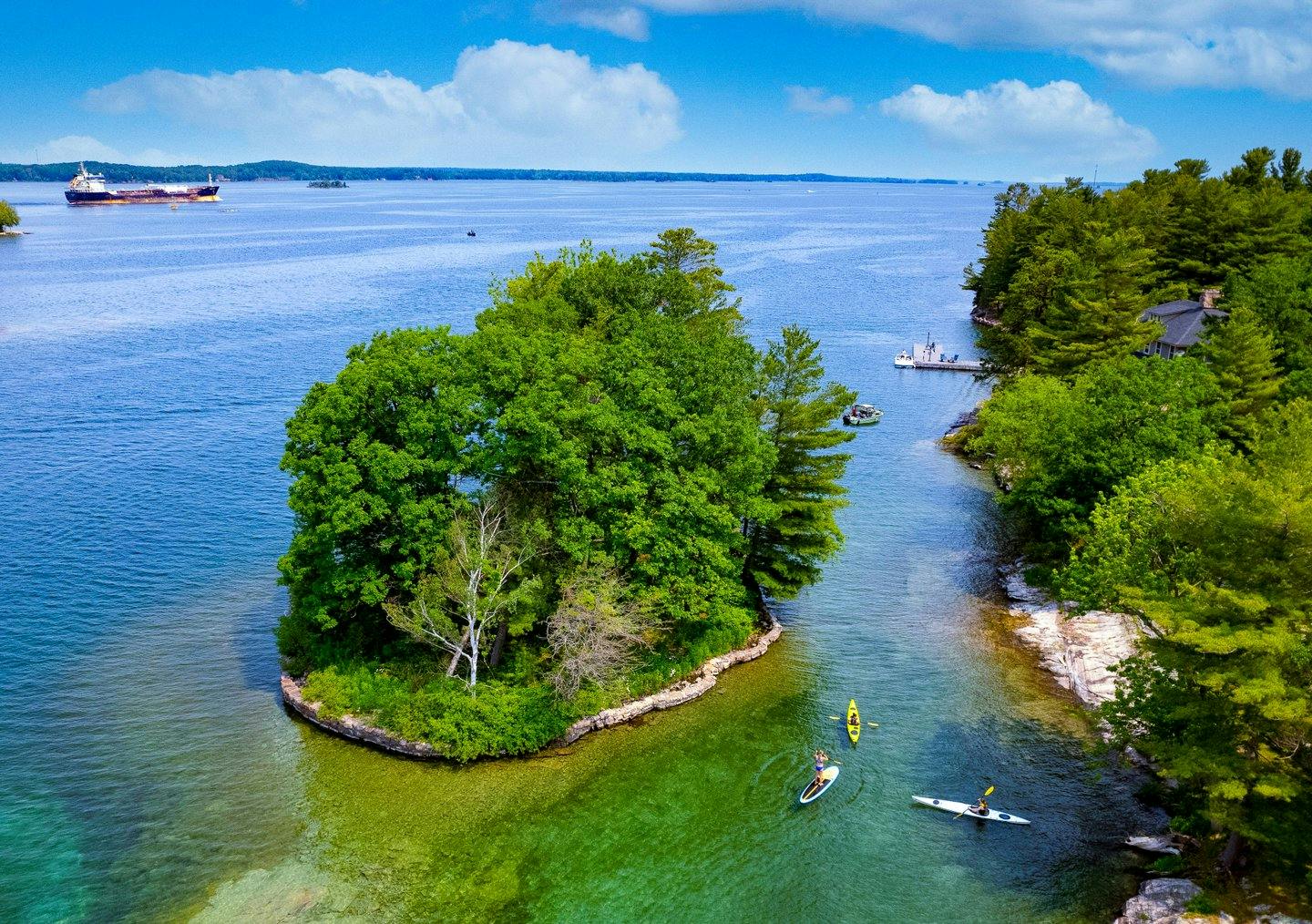 Aerial photo of a lush green island floating in clear, turquoise waters.