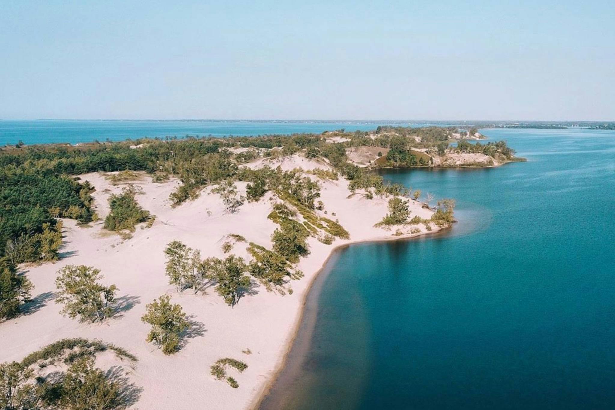 Sandy beaches hugging clear blue water of Sandbanks.