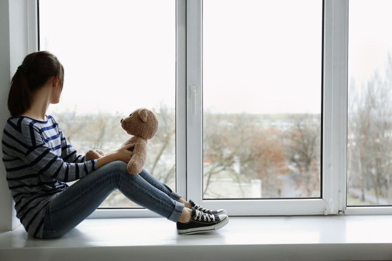 young girl looking out of window