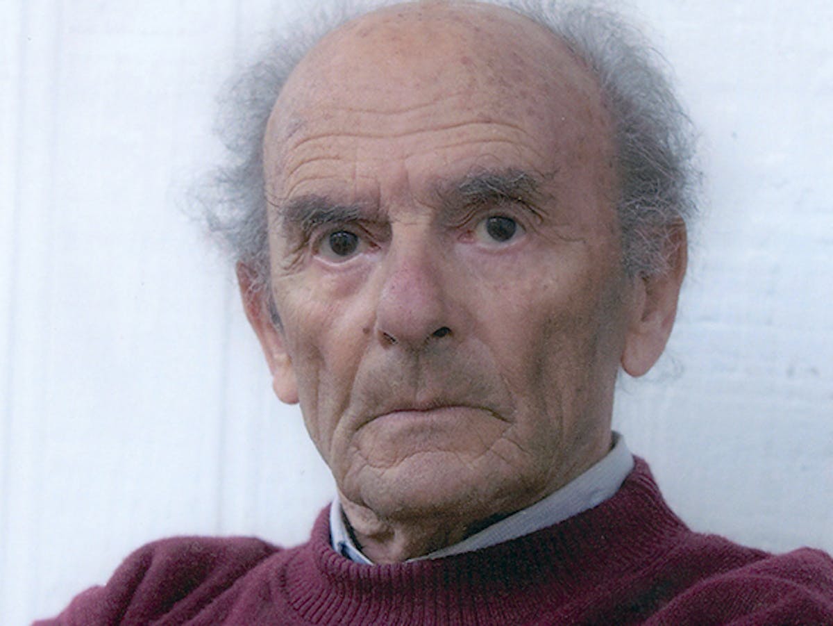 Portrait photo of an elderly man with thinning grey hair