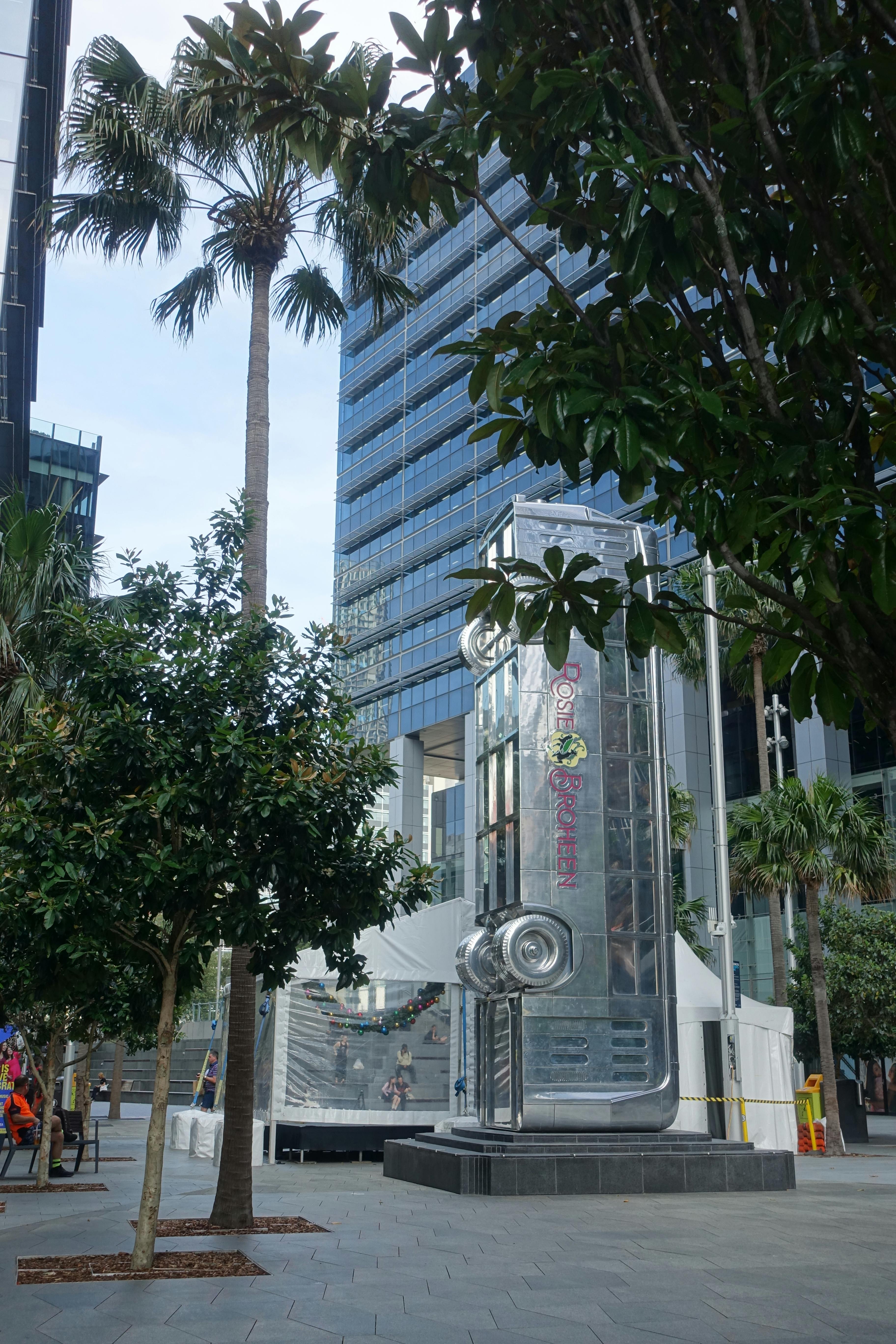 View of the public art structure ‘Place of the Eels’,  an eight-metre, vertical, highly reflective chrome vintage bus, in Parramatta Square.  