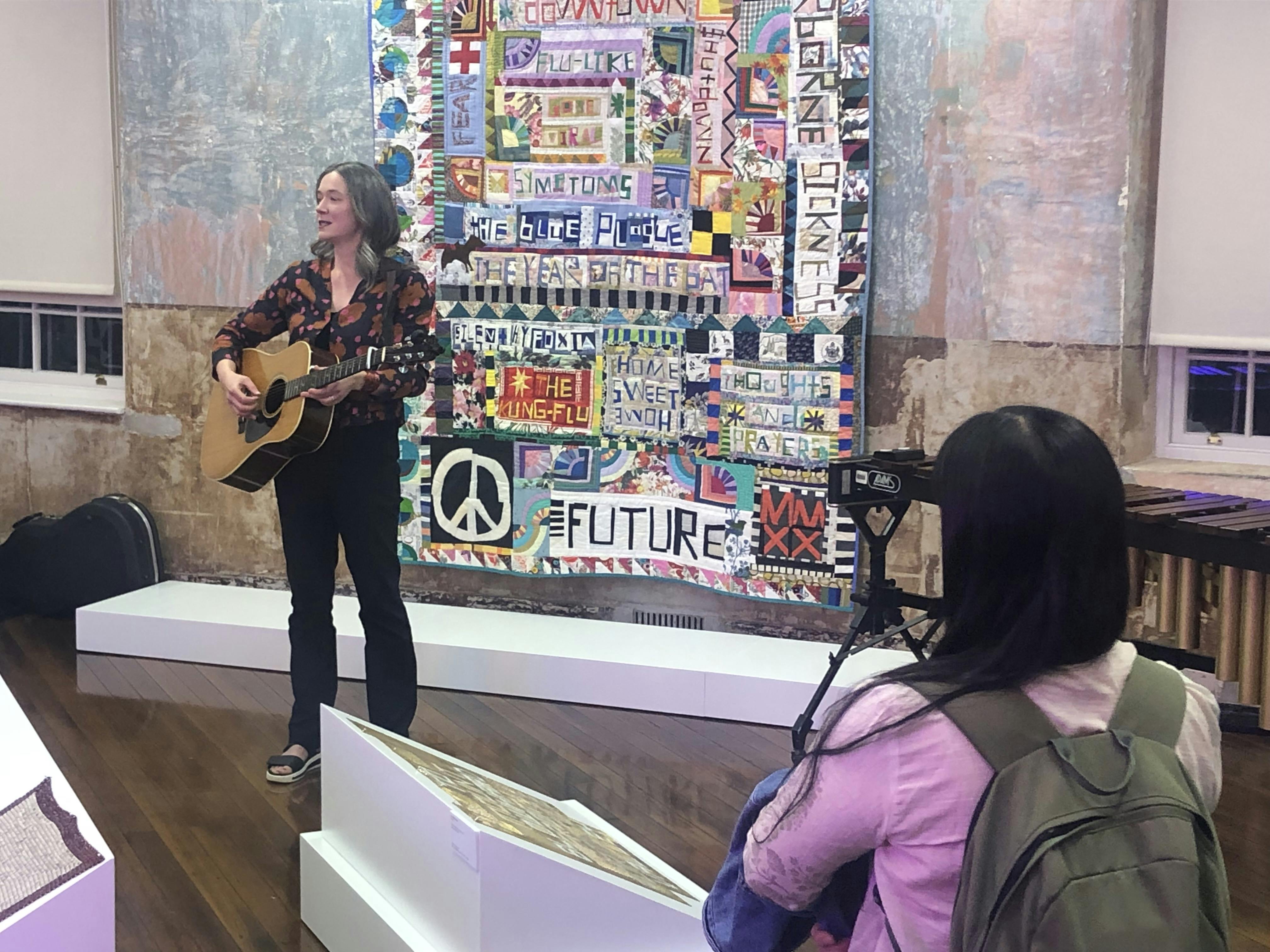 Poet Kate Fagan playing the guitar at the launch of her book ‘Song in the Grass’. 