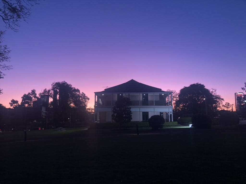 A photo of the Margaret Whitlam Galleries building against a deep blue and vibrant purple night sky.