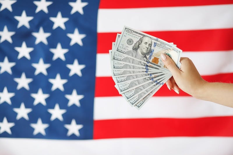 Money with an American flag behind Money with an American flag behind