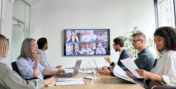 Conference business meeting with video call on monitor