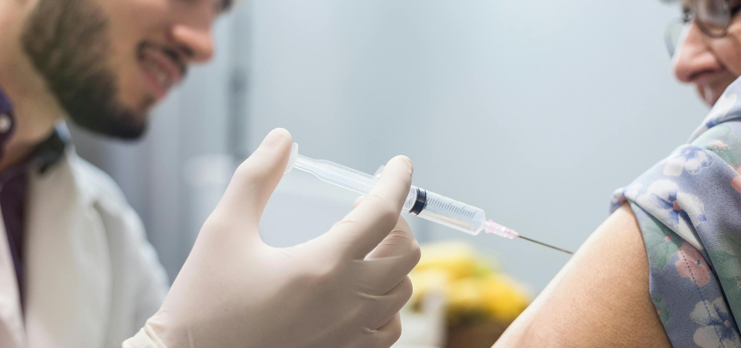 un infirmier qui vaccine une personne âgée