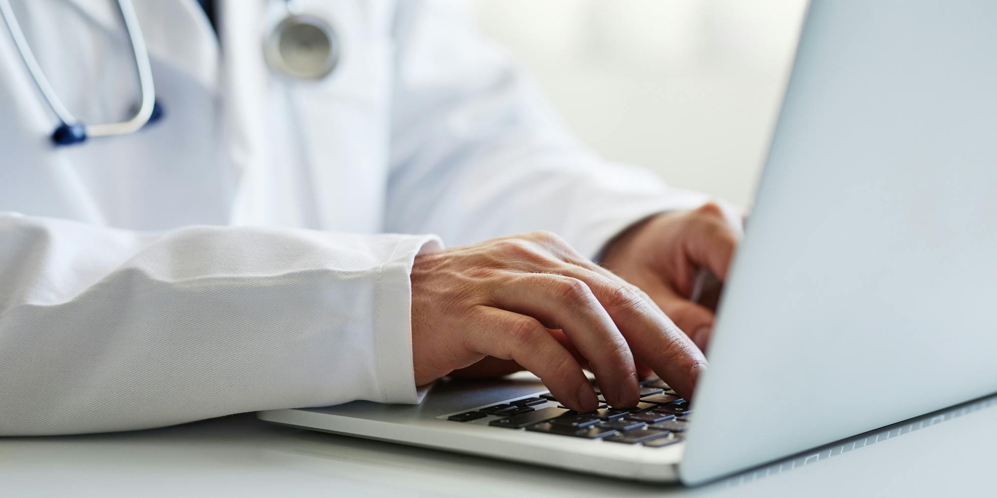 un docteur tapant au clavier sur un ordinateur portable