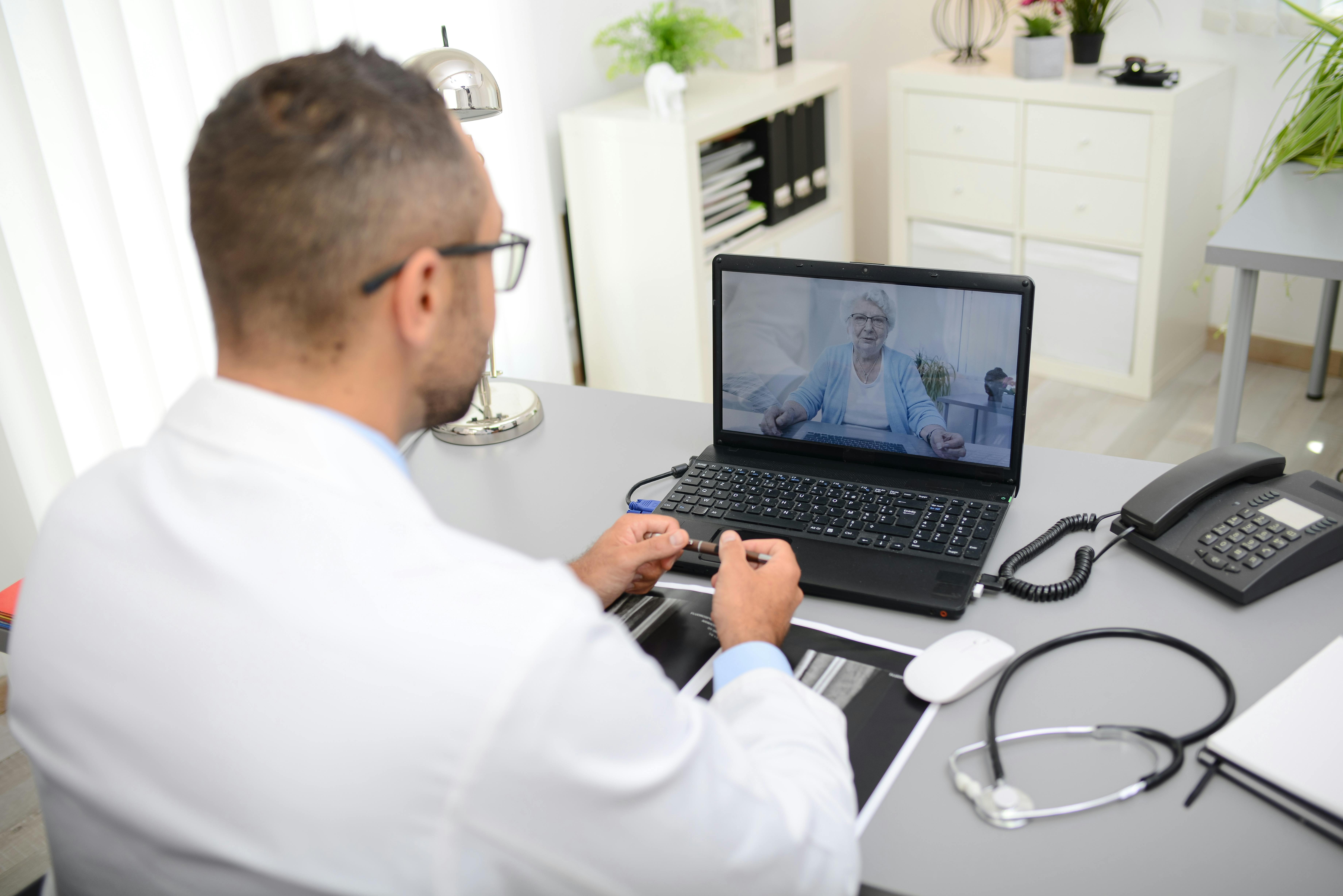 un médecin pendant une consultation en télémédecine avec une personne âgée