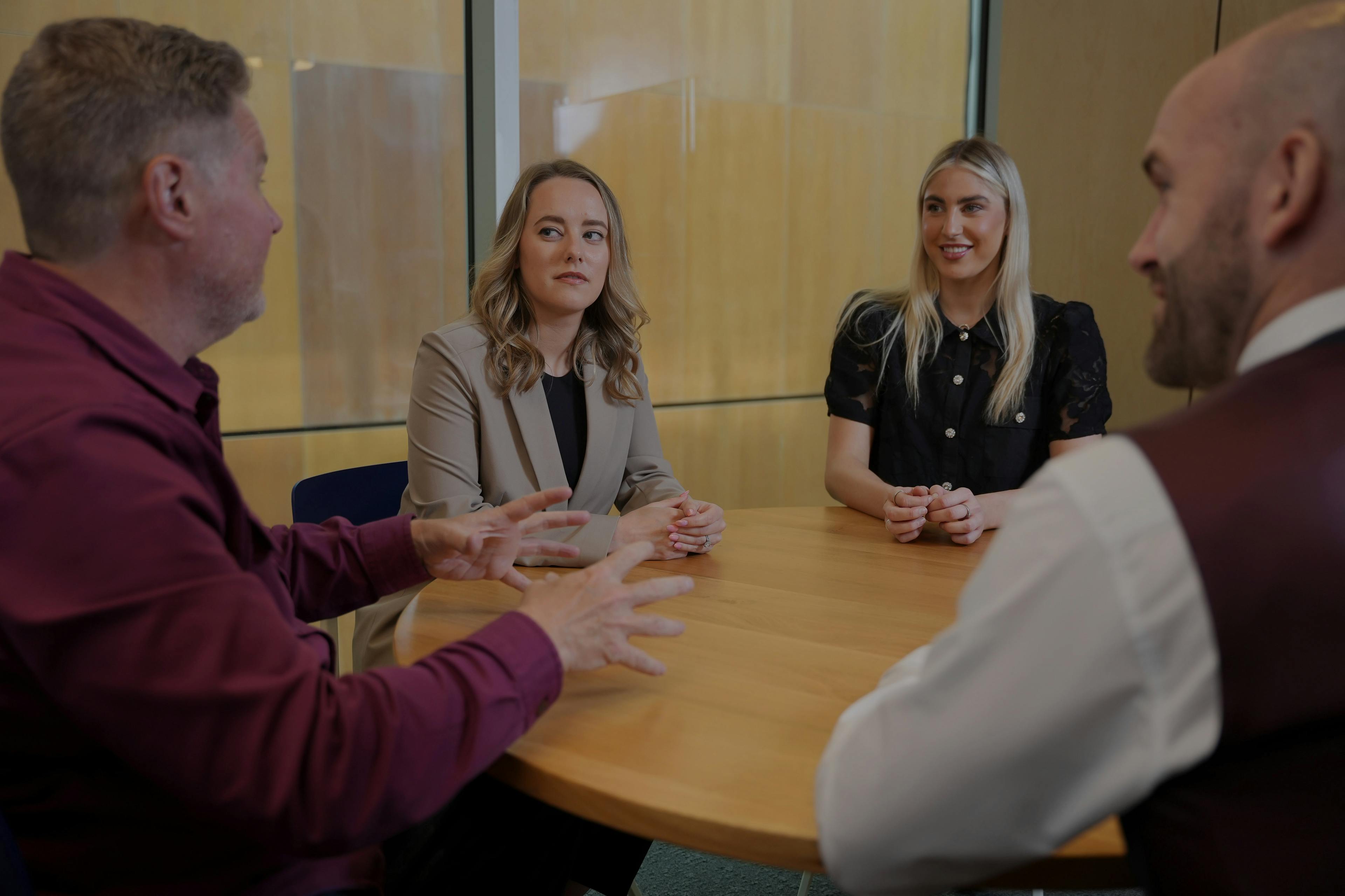 Three seniors and employee discussing on round table