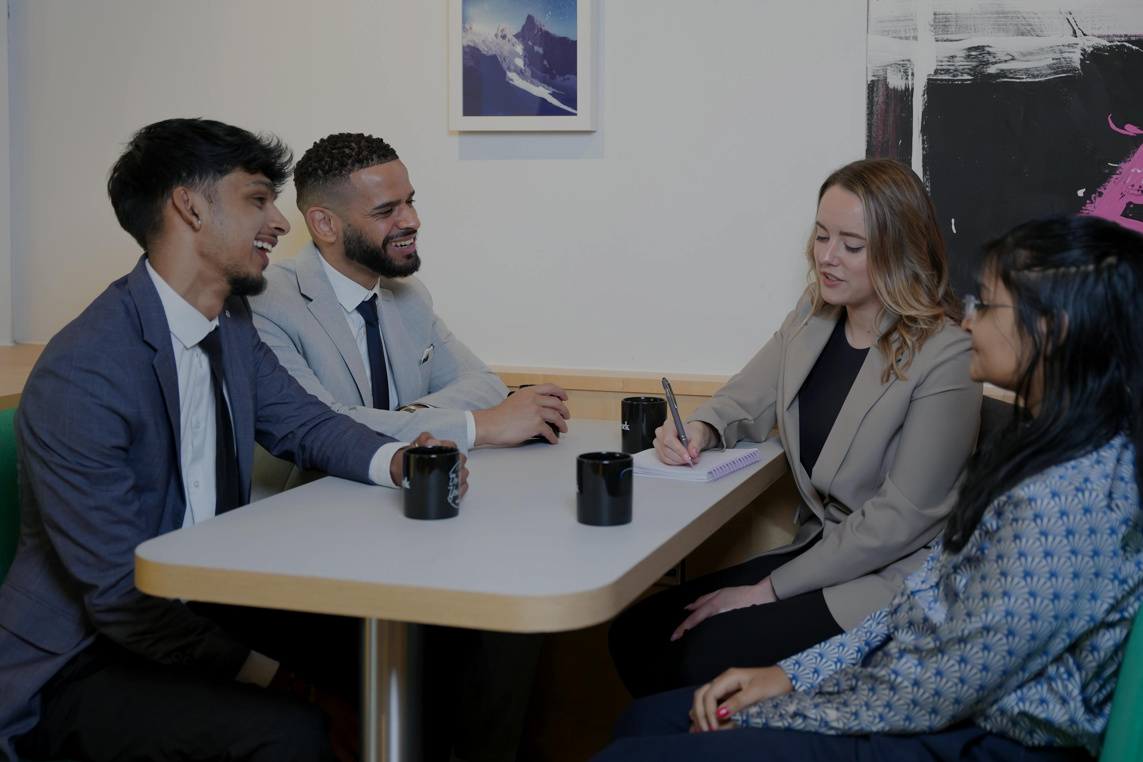 Four colleagues in the kitchen having a discussion 