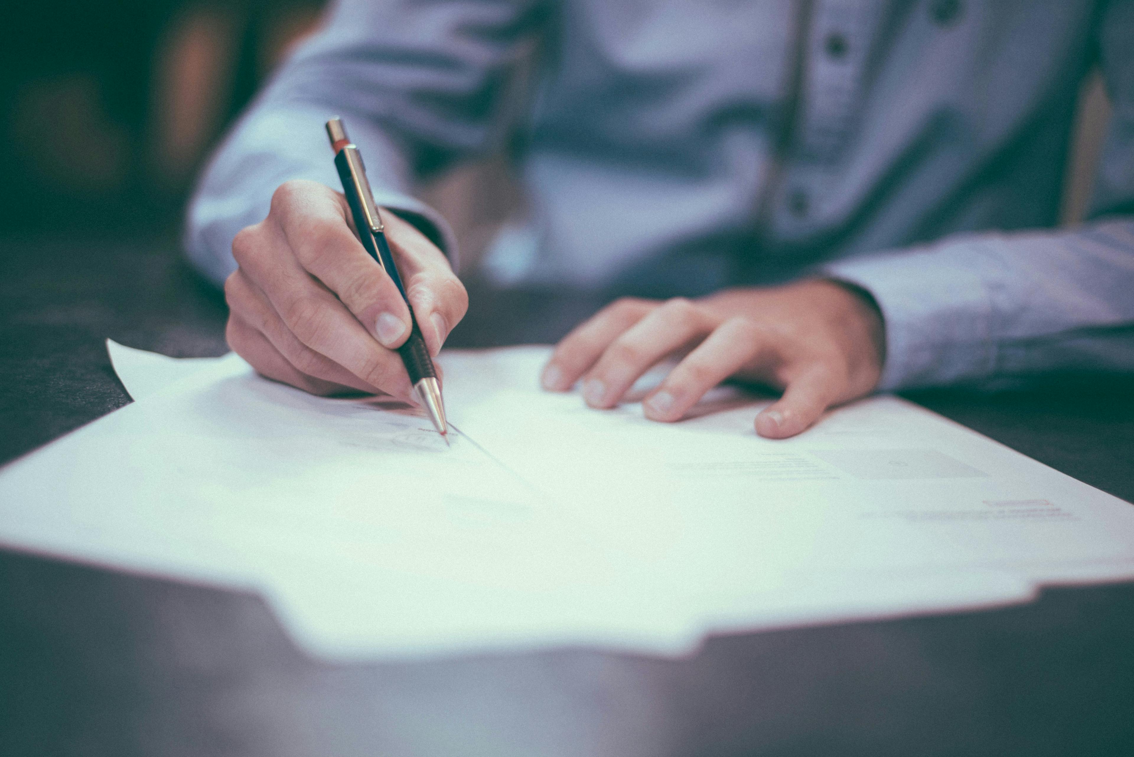 Image of man writing with pen