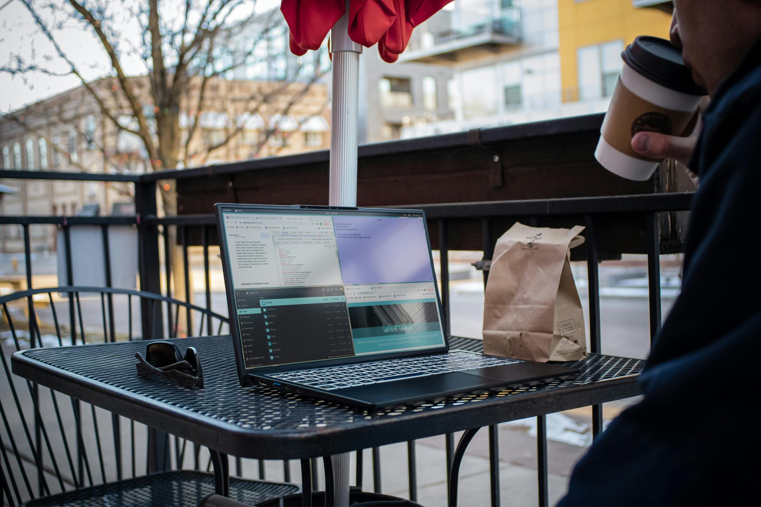 A person working in the outdoor seating area of a cafe.