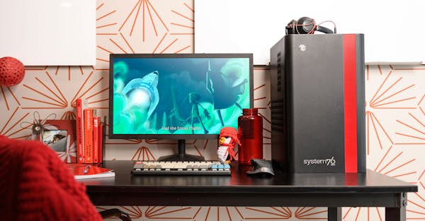 Thelio Mira desktop with red accent on a desk with launch keyboard