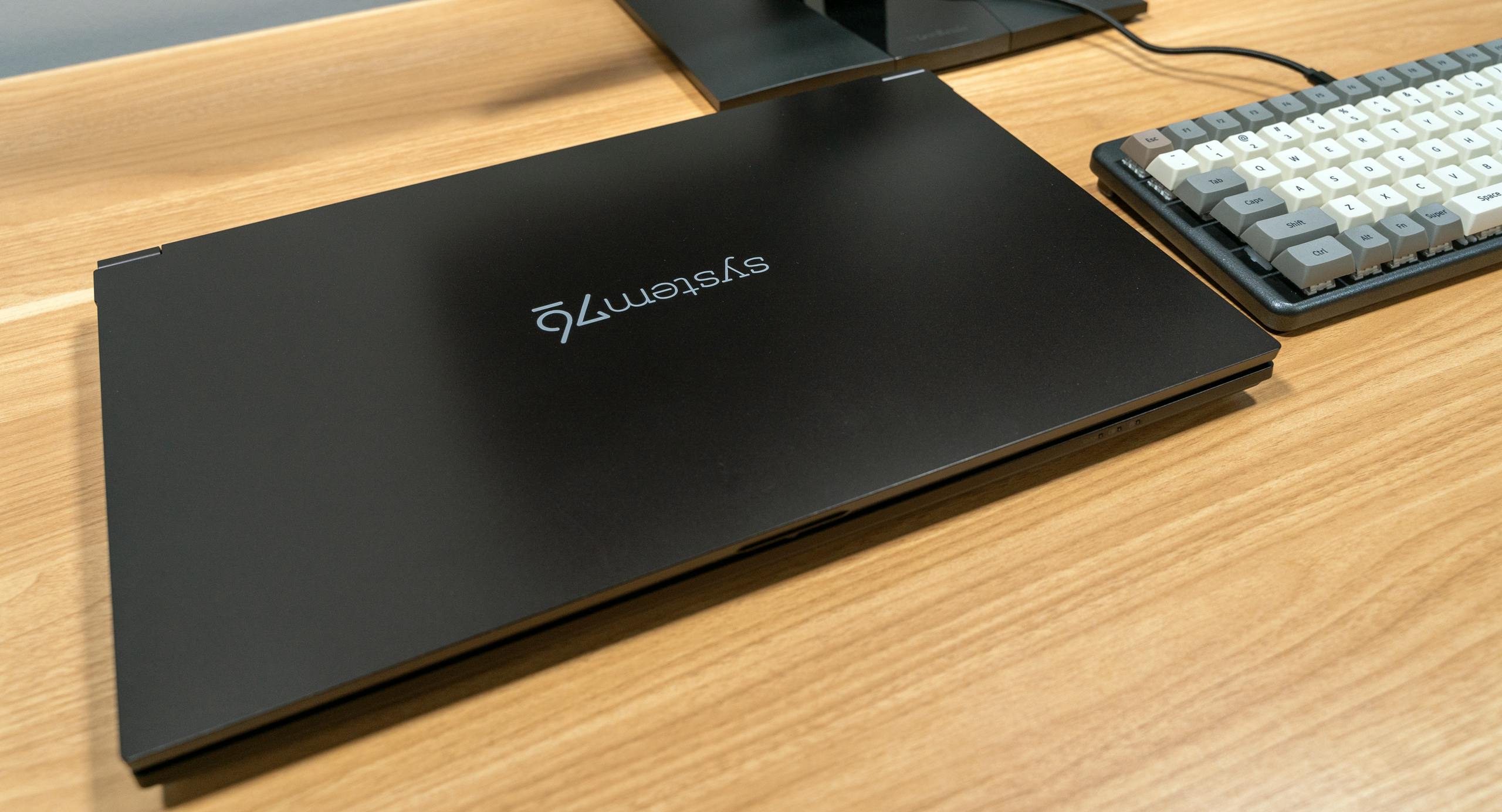 The Gazelle laptop on a desk next to a computer launch keyboard and external monitor.  