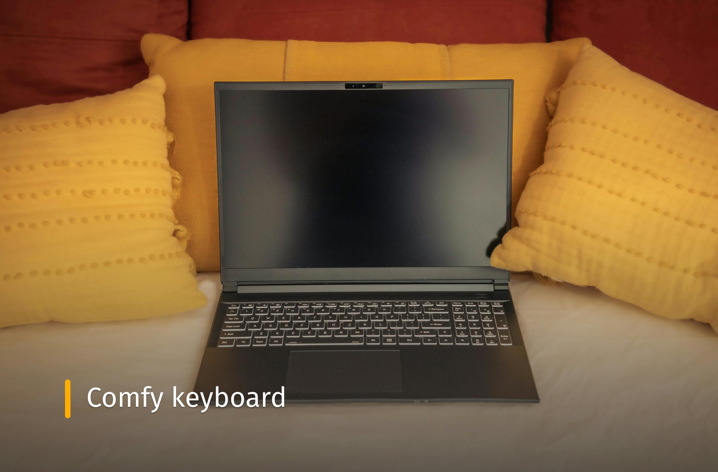 Darter Pro on a bed with yellow pillows and text that reads "Comfy keyboard"