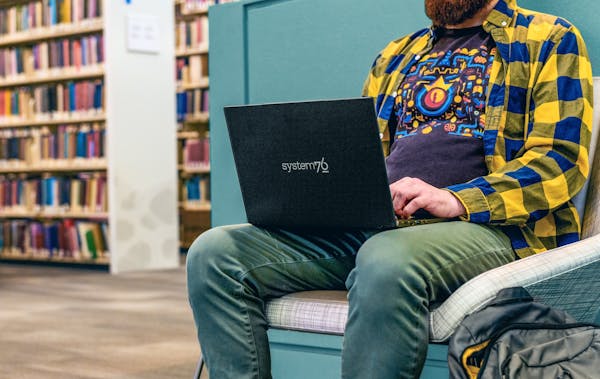The lightweight Lemur Pro sits in the lap of a student while they work at a library. 
