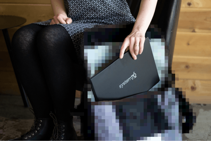 A person storing their Lemur Pro laptop in their System76 messenger bag.
