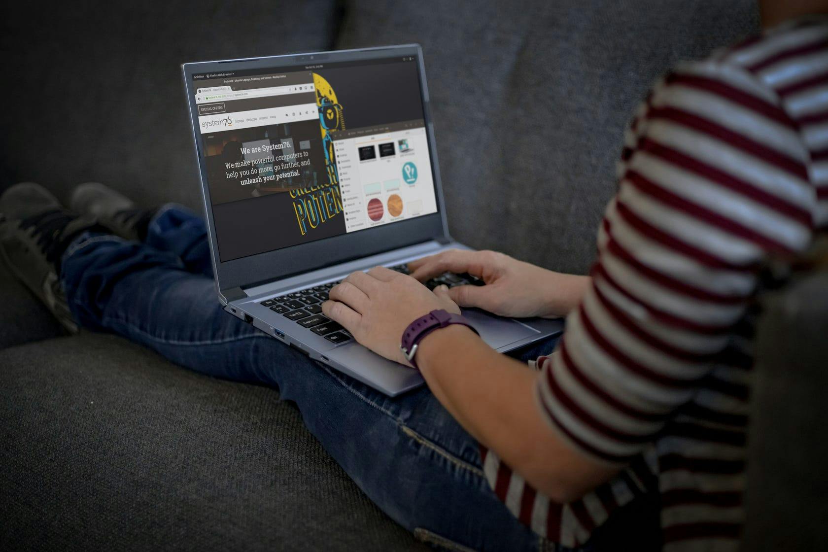 A person working in Pop!_OS on the Galago Pro while seated comfortably on a couch.