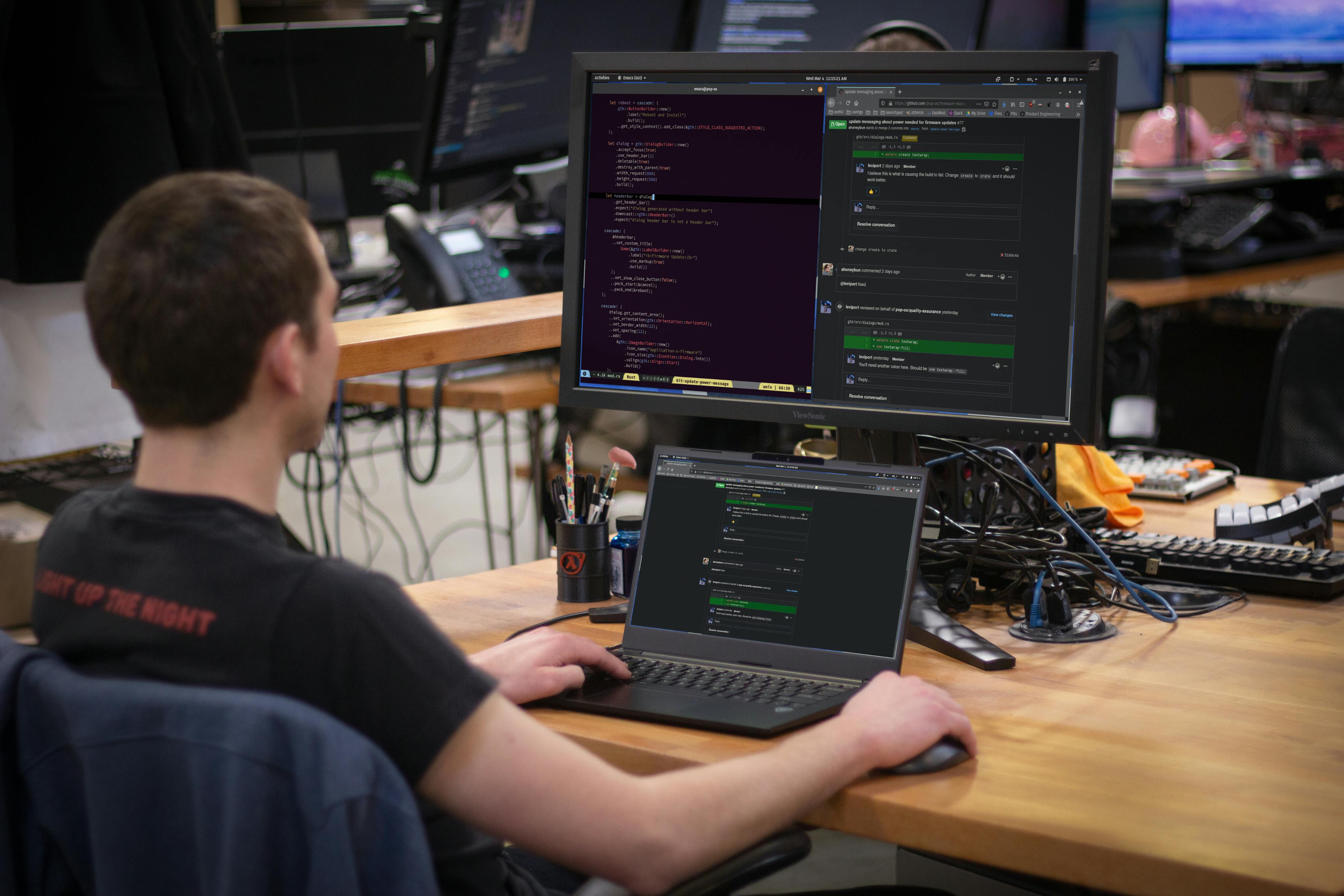A person using both a Lemur Pro laptop and external monitor for coding.