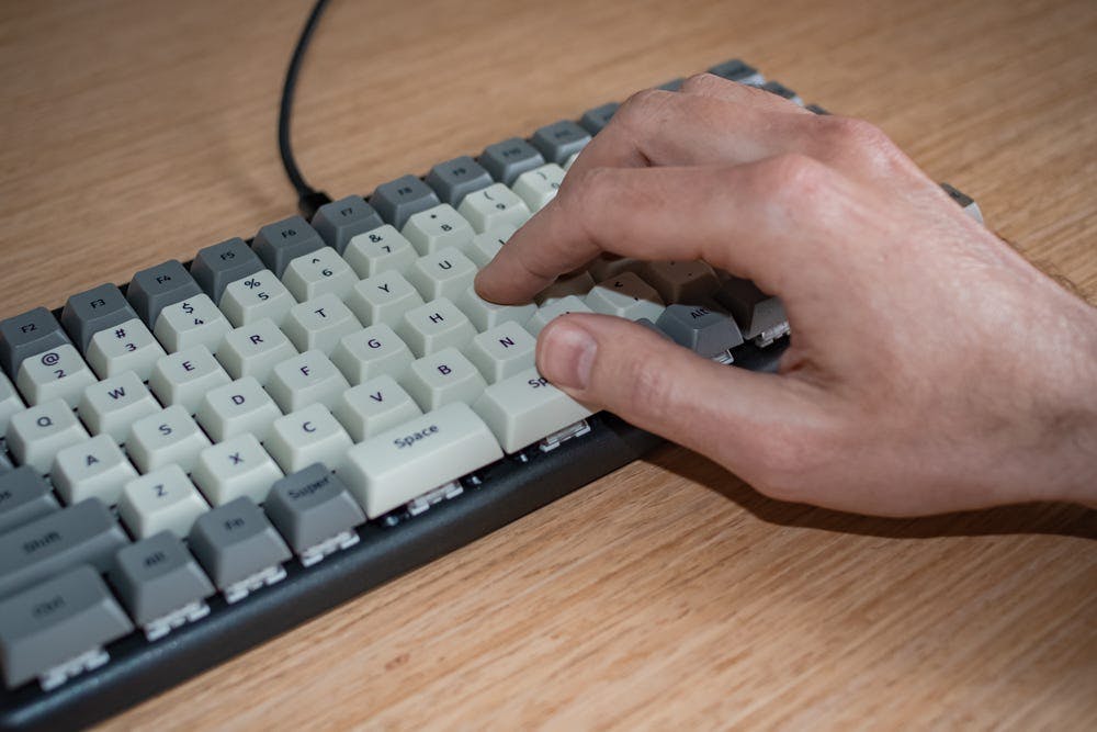 A person’s right hand resting on the keyboard, their thumb on the right Space bar, other fingers on the home row.