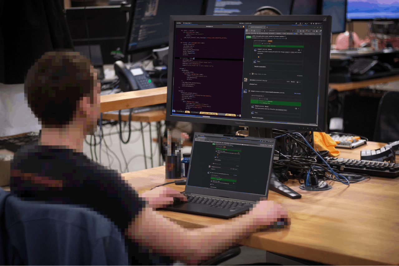 A person using both a Lemur Pro laptop and external monitor for coding.