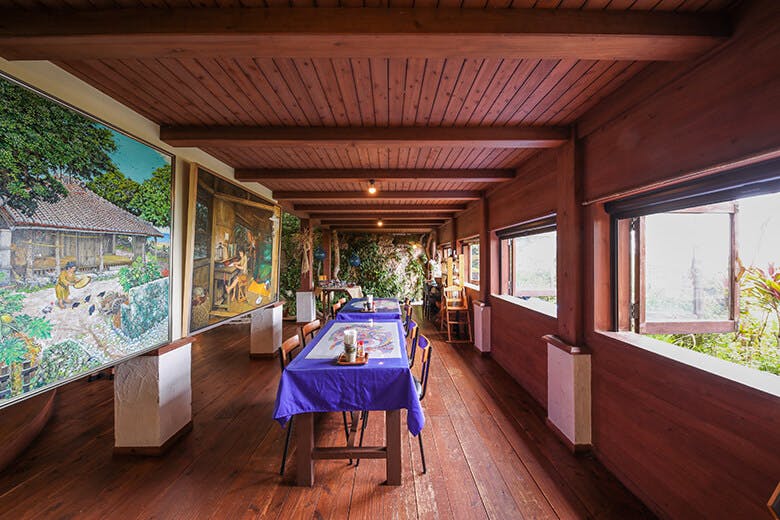 山の茶屋 楽水｜画家 野津 唯市（のづ ただいち）さんが描いた「懐かしい未来　沖縄」の原画が展示されている店内スペース