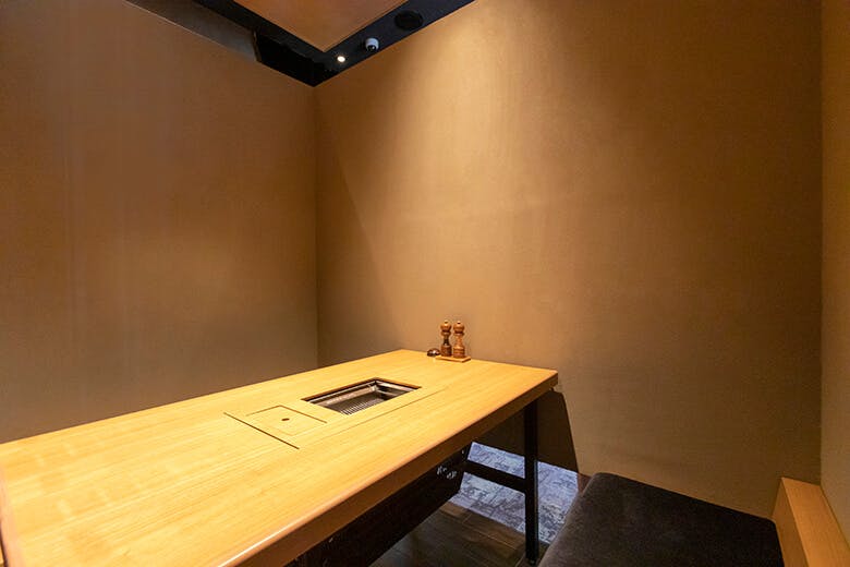 焼肉 琉球の牛｜木製のテーブルと上質なロースターが設置された個室