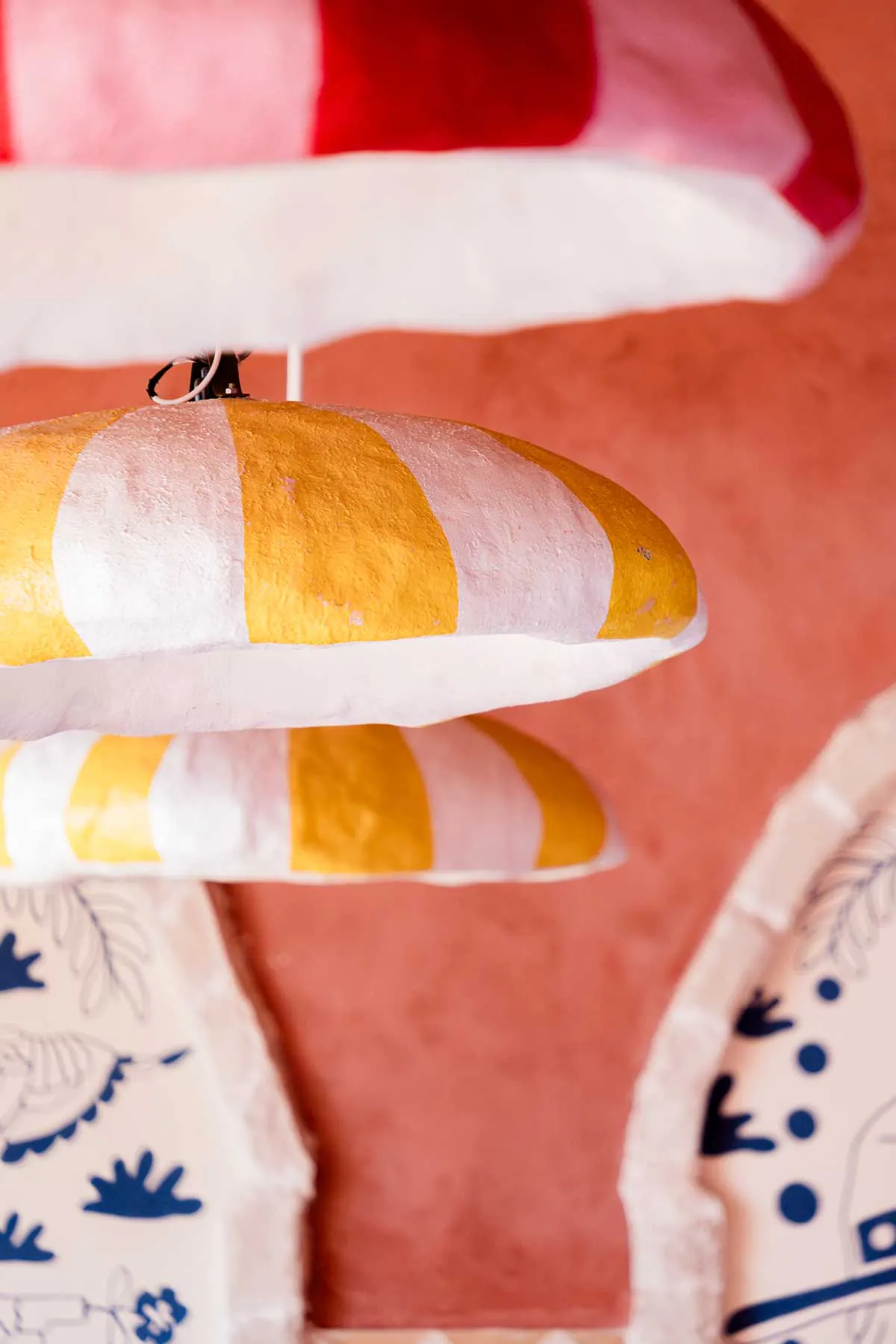 Striped pendant lights hanging against a terracotta wall at a Mexican restaurant in Bali