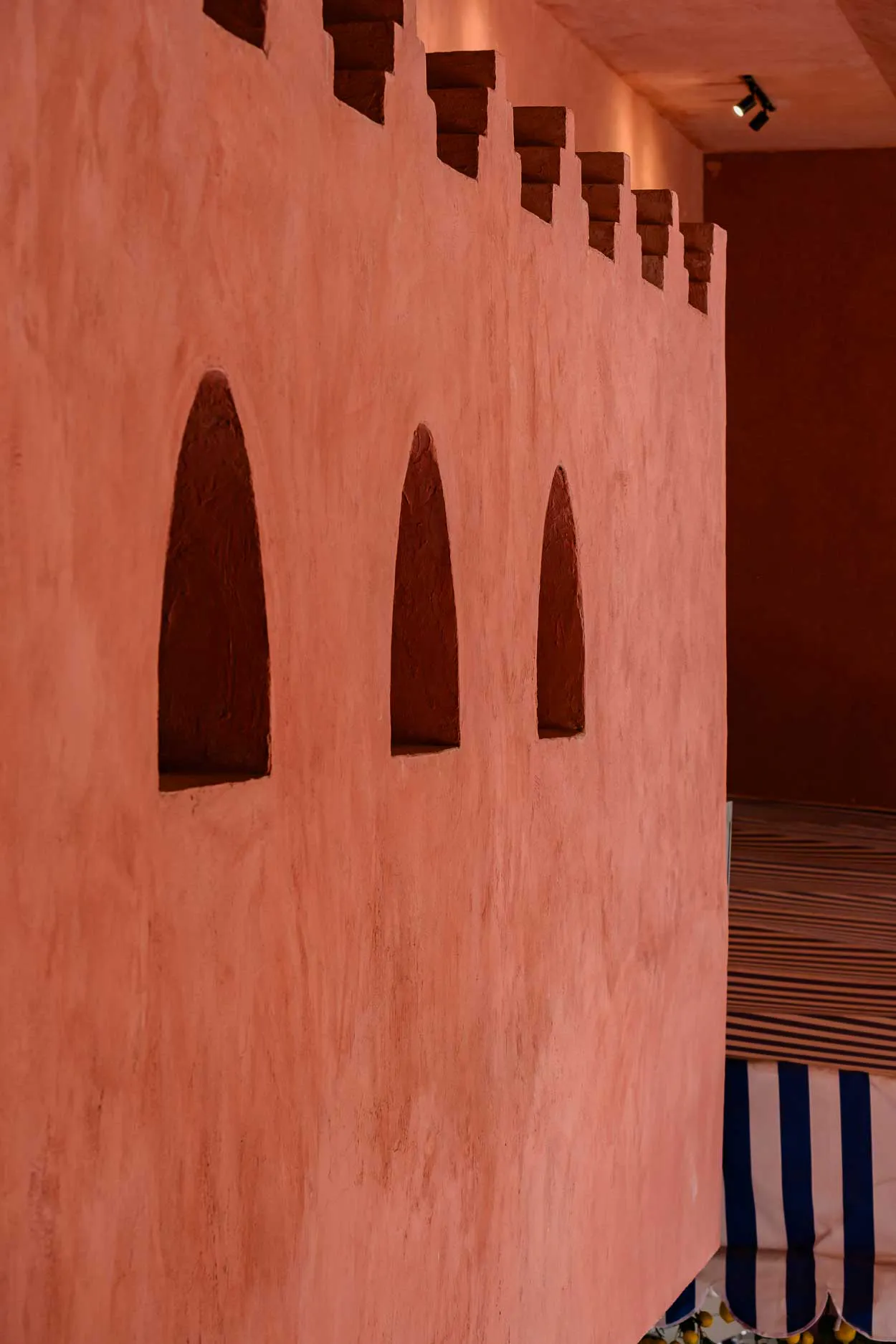 pink stucco wall with arched niches inside a Mexican restaurant in Bali