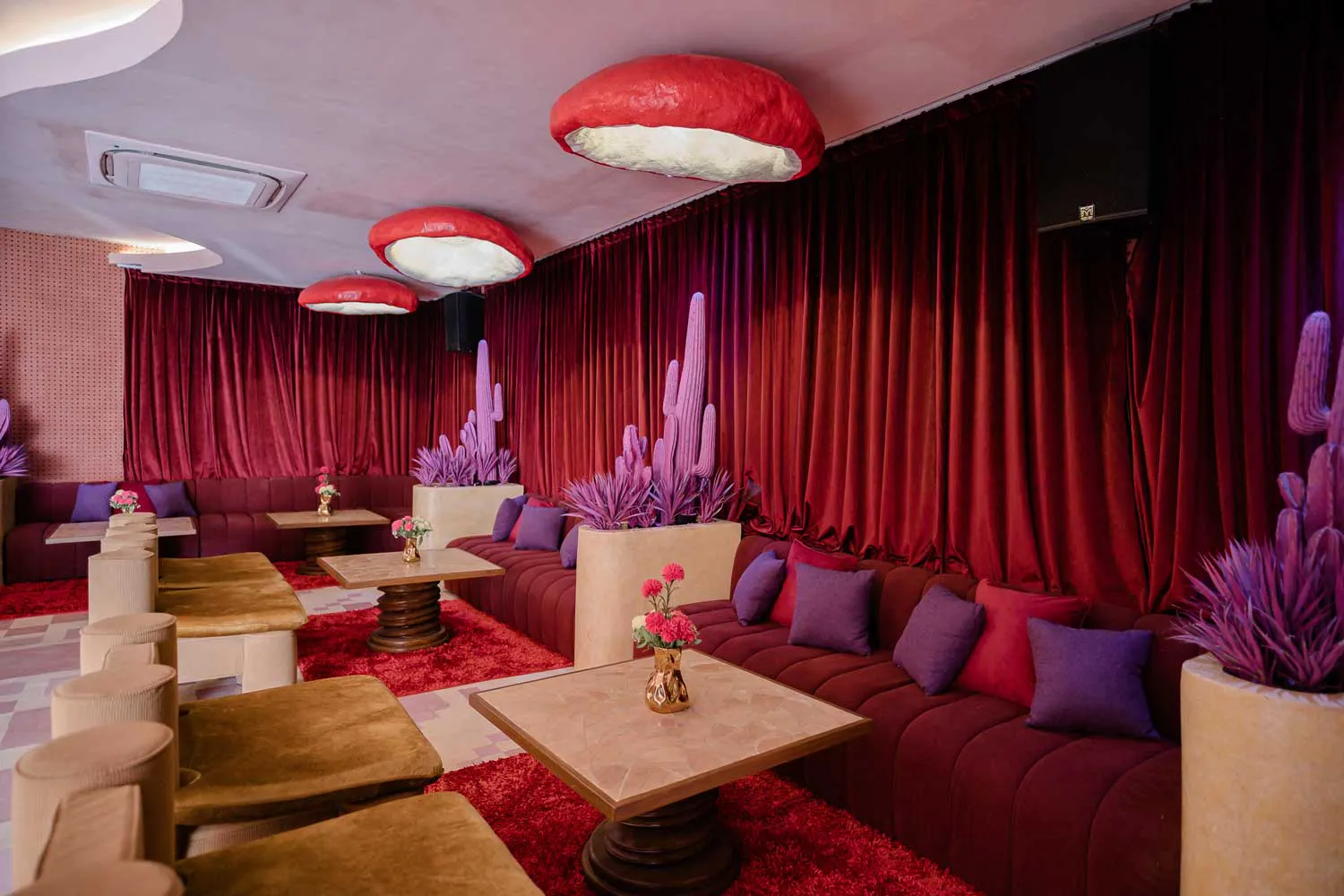 Function room at Mexican restaurant Uluwatu Bali with burgundy velvet sofas, purple cactus decor and red shag carpet