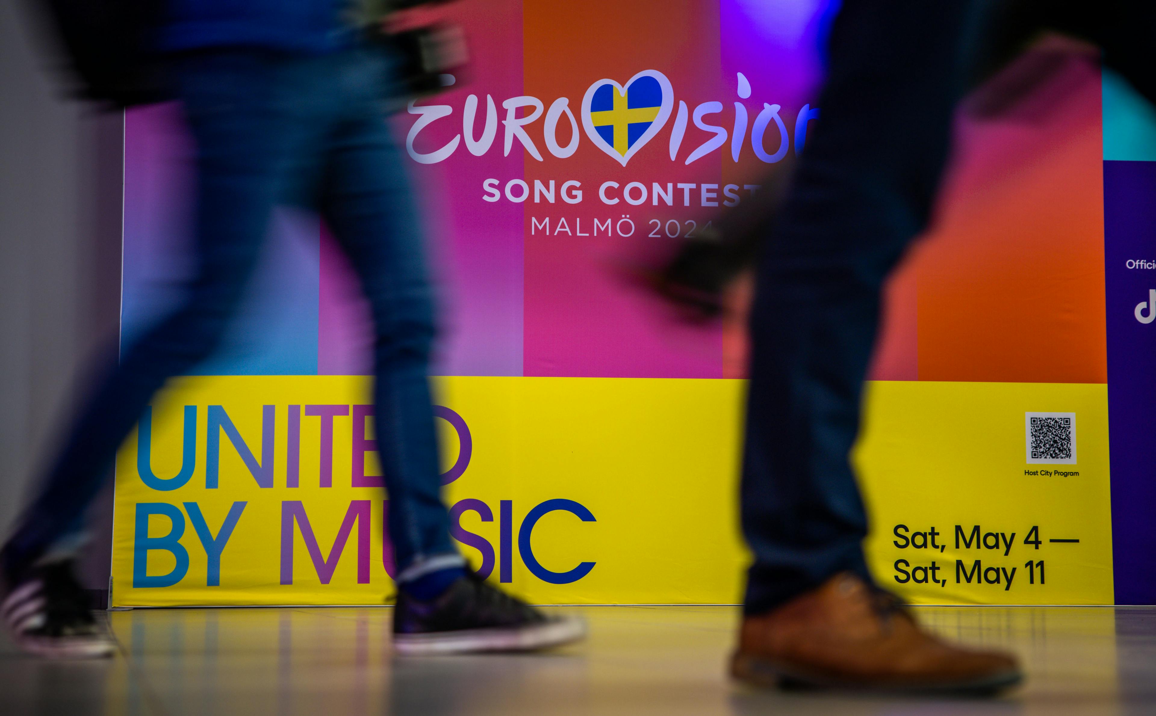 People walking by the United by Music banner