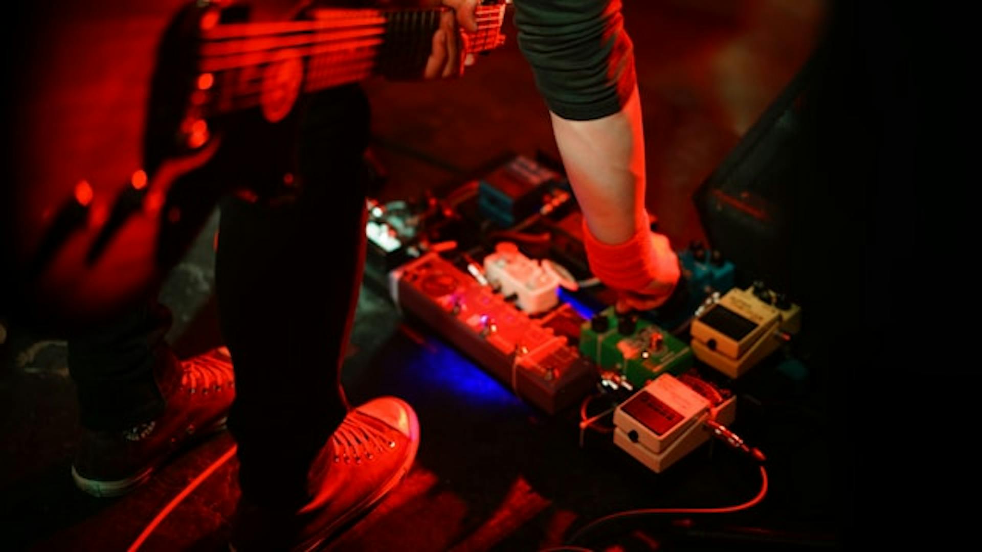 Guitarist with equipment on stage.